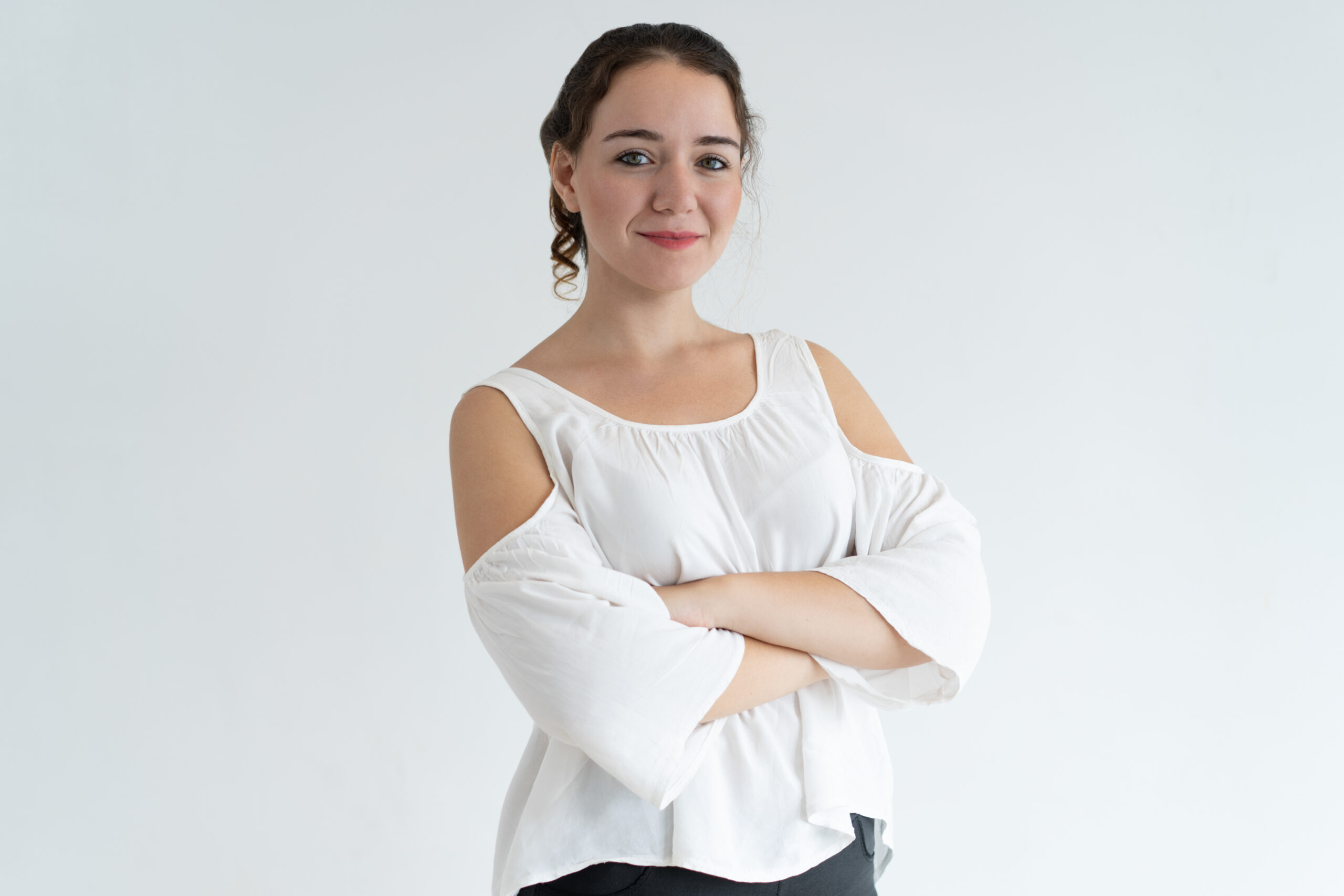 Confident lovely woman looking at camera. Young wavy-haired lady posing with her arms crossed. Beautiful woman portrait concept. Isolated view on white background.